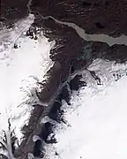 Imagen mostrando pequeños glaciares derramando en un valle principalmente seco en el oeste de Groenlandia.