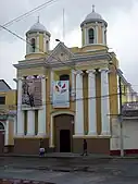 Iglesia de San Juan de Dios. Frente a la iglesia, Willy obliga a Paco a hincarse y confesarse.