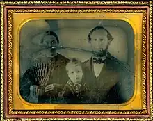Fotografía familiar en blanco y negro rodeada por un marco dorado.