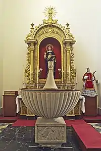 Retablo de Santo Tomás de Aquino y pila bautismal