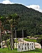 Cartel de entrada de la ciudad, con el Pico de Ojo De Agua al fondo