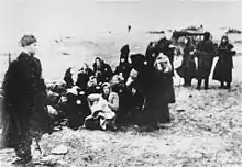 Miembros del 21º Batallón Policial Lituano hacen formar a un grupo de mujeres judías para su ejecución en una playa cerca de Liepāja, 1941.