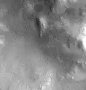 Canal en el cráter Lyot, tomada por CTX. Se han descubierto canales tallados por agua en el cráter Lyot; la línea curva puede ser una de ellos
