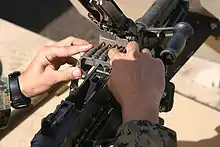 Un infante de marina carga rondas en su M240G antes de disparar el curso de distancia desconocida el 5 de octubre en el campo de tiro 8 dentro del área de entrenamiento de Pohakuloa. Foto por: Cpl. Rick Nelson Identificación con foto: 2006101321226 Unidad de envío: MCB Hawaii Fecha de la foto: 10/05/2006