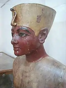 Maniquí de Tutankamon Hecho de madera policromada con el rostro del rey, cortado en caderas y hombros, para exhibir vestidos. Fue hallado en su tumba, y pertenece a la XVII dinastía
