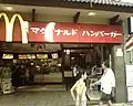 Antigua fachada de McDonald's escrita en katakana: マクドナルド ハンバーガー (Makudonarudo Hanbāgā, "Hamburguesas McDonald's").