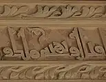Detalle de la decoración epigráfica en uno de los frisos del salón