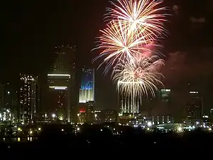 La torre iluminada como la bandera de Estados Unidos en el Día de la Independencia, con fuegos artificiales en primer plano