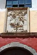 Relieve tallado sobre el portal principal dedicado al Arcángel San Miguel.