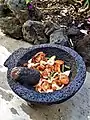 Molienda de salsa picante en molcajete procedente de San Salvador El Seco, Puebla, México.