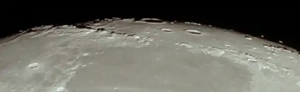 Vista del limbo de la luna mostrando los Montes Apenninus (izquierda), los Montes Caucasus (derecha), el este del Mare Imbrium (arriba), y el oeste del Mare Serenitatis (abajo), desde el Apolo 11