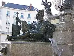 Statue en bronze sur socle de granit ; l'eau jaillit d'une amphore