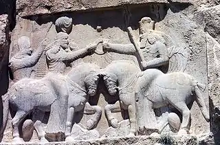 Investidura de Ardacher I (fundador de la dinastía sasánida, en el siglo III) por el dios Ahura Mazda. Sus caballos pisotean al anterior rey, Artabán IV, y a la deidad negativa Ahriman. Naqsh i Rustam.