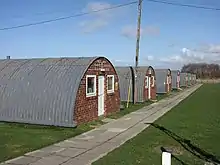 Conjunto de cobertizos Nissen en Altcar Training Camp, Hightown, Merseyside, todavía en uso en 2019. A menudo se usan como lugares de filmación, incluido el drama de Russell T Davies de 2019 Years and Years .