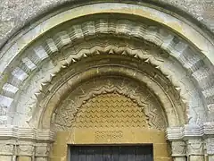 Portal de Guiting Power, Gloucestershire, imitando un opus reticulatum en relieve sobre el tímpano.