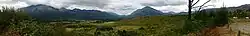 Panorámica de El Hoyo. A la izquierda el Cerro Piltriquitrón (cordón occidental y luego oriental), a la derecha el Cerro Los Patos, atrás al centro el Cerro Coihue, y en centro derecha se destaca el Cerro Pirque. Bien a la derecha, la Ruta 40.