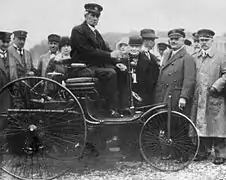 Fotografía de 1914, con Karl Benz como conductor, y su esposa Bertha entre el público.