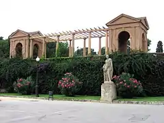 Estatua y pérgola decorativa en la entrada al recinto.