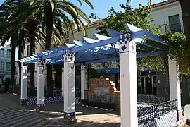 Pérgola que encuadra el azulejo representando el cuadro "Ayamonte" de Sorolla.