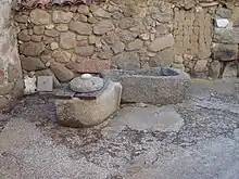 Brocal de pozo y pila de granito en un antiguo corral