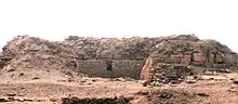 Low ruins in the desert, looking like a wall.