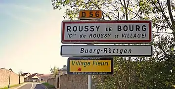 Una señal de entrada bilingüe en Roussy-le-Bourg.