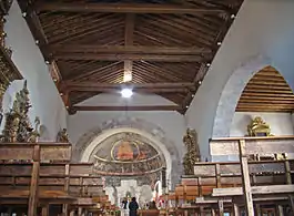 Interior del templo. Artesonado de madera y ábside con pinturas.