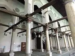 La sala de oración de la mezquita Salih Talai , con contornos de estuco caligráfico alrededor de los arcos y vigas de madera talladas de la época fatimí.