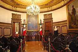 Salón del Cabildo del Ayuntamiento de México. Nótese el escritorio central que tiene un escudo antiguo.