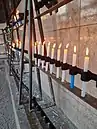 Candelabros colocados a la izquierda de la virgen junto a diversas velas que llevan de oraciones puestas por creyentes en 2021.