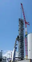 Fotografía de una alta torre de lanzamiento de acero blanco con una plataforma en la parte superior