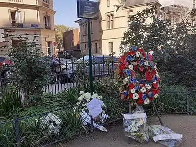 El jardín y las flores del homenaje. Al fondo, los arboles del bulevard Saint-Michel.