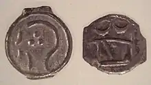Moneda británica de Sunbury-on-Thames, 100–50 a.C., mostrando la estilizada cabeza de Apolo y el toro embistiendo.