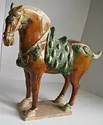 Caballo de guerra de la dinastía Tang (de los denominados celestiales o de Ferghana), representado en cerámica sancai.