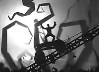 La silueta de un hombre que sostiene sus brazos en el aire se alza sobre una plataforma con ruedas que asciende a una viga diagonal. El telón de fondo es brumoso y blanco, con siluetas de árboles curvos y formas visibles.