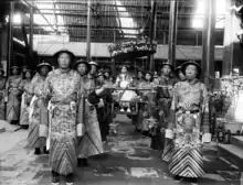 Photo of the Empress Dowager Cixi in a sedan chair, surrounded by many eunuchs