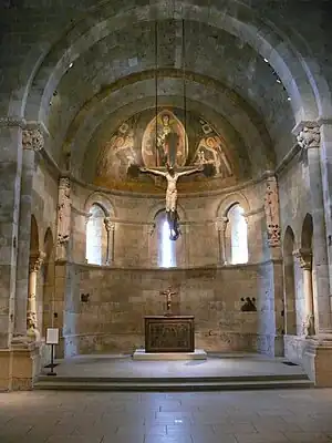 Reconstrucción de un altar mayor románico en The Cloisters. Se dispone un pequeño crucifijo sobre el altar y se cuelga un crucifijo de grandes dimensiones de la bóveda.