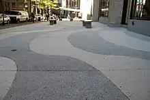 Alternating bands of white and gray tiles in the sidewalk of the plaza outside 1271 Avenue of the Americas