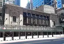 Teatro Times Square en construcción con una valla en frente de él.