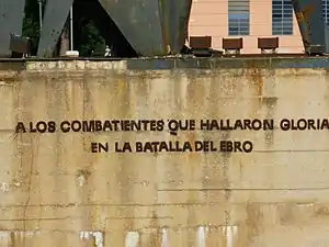 Aún tras la retirada de los símbolos franquistas, la base todavía tiene la dedicatoria «A los combatientes que hallaron gloria en la batalla del Ebro».