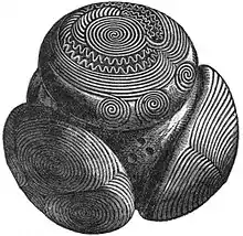 Un ejemplo de bola de piedra tallada encontrada en Towie, Aberdeenshire, datado entre 3200 y 2500 a. C. La bola está decorada profusamente con ondas, círculos, espirales, puntos y otras formas.
