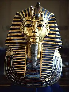 Máscara funeraria de Tutankamon, hecha de oro con incrustaciones de piedras preciosas y joyas. Representa el rostro idealizado del faraón de la XVIII dinastía