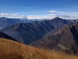 Val Grande, Pizzo Proman (la montaña más alta a la derecha), Cicogna (el pueblo pequeño en la esquina inferior derecha) y el Monte Rosa (izquierda, cubierto por nubes), vistos desde Pizzo Pernice