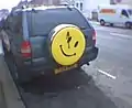 Imagen de un smiley en la parte trasera de un jeep.