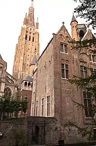 Estilo flamenco en ladrillo en Brujas, Bélgica, con la alta torre de la iglesia de Nuestra Señora