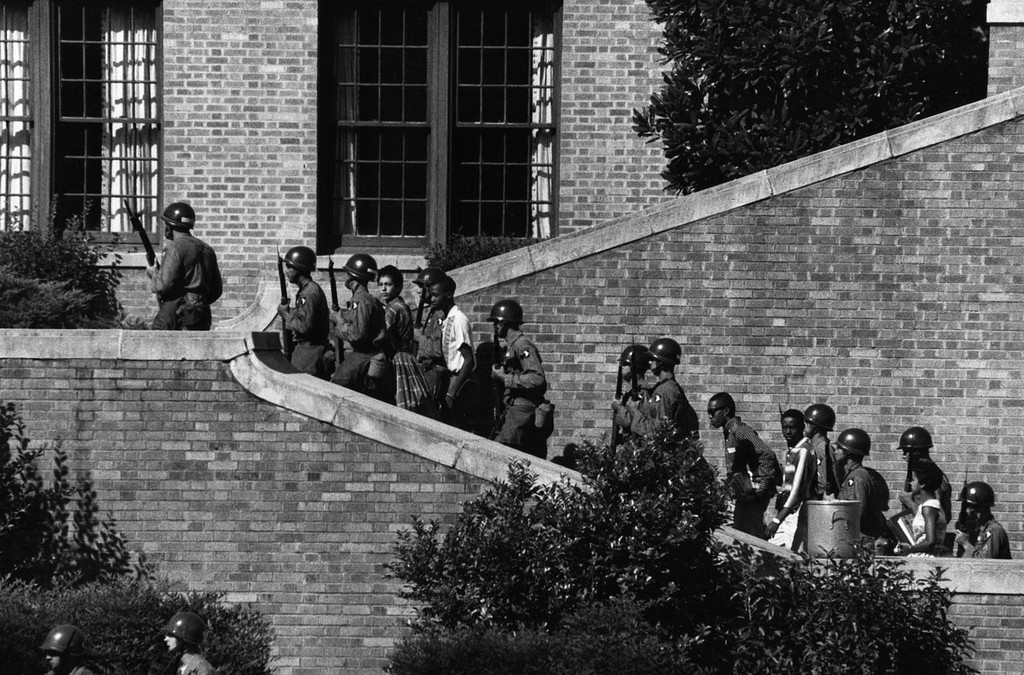 
Soldiers from the 101st Airborne Division escort  nine black students into the all-white Central High School in Little Rock, Arkansas, after the Supreme Court declared school segregation to be unconstitutional (1957).   