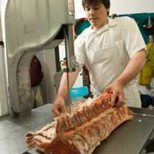 person using a machine to cut meat