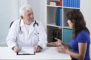 Photo of a young woman asking her doctor questions