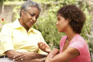 Photo of an adult daughter consoling her mother