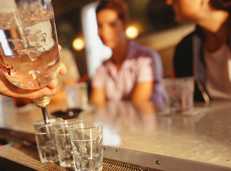 Two women ordering alcohol from a bar